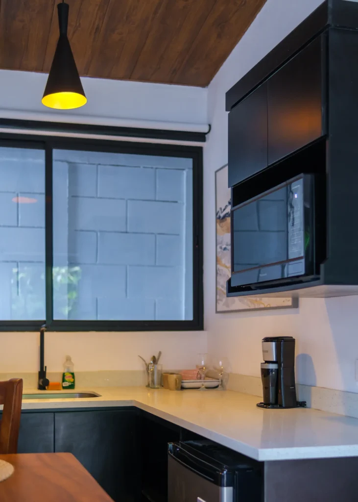 Pequeña cocina con electrodomésticos modernos en suite tipo cabaña equipada cerca del Volcán Poás.
