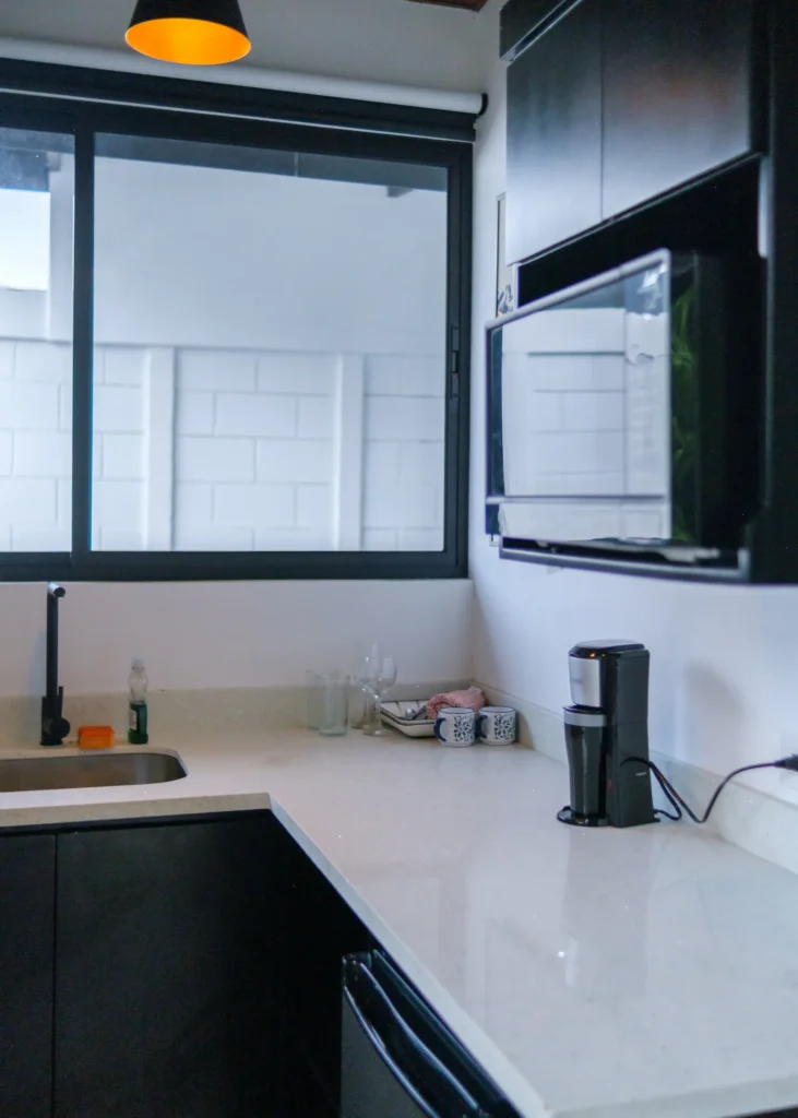 Pequeña cocina con electrodomésticos modernos en suite tipo cabaña equipada cerca del Volcán Poás.